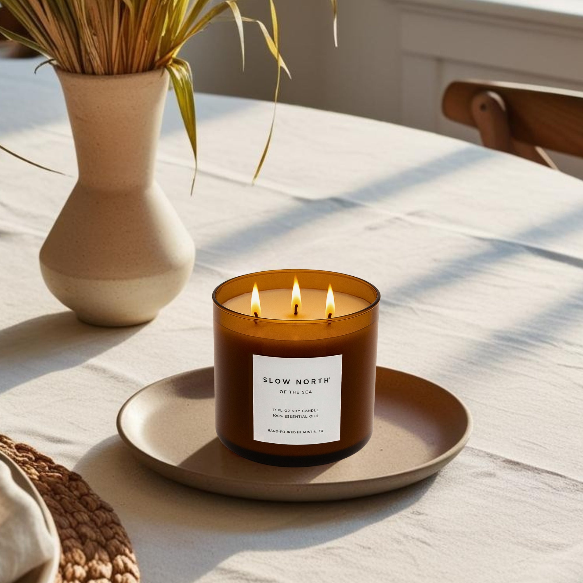 3-Wick Candle in an Amber Jar burning on a relaxing coastal table