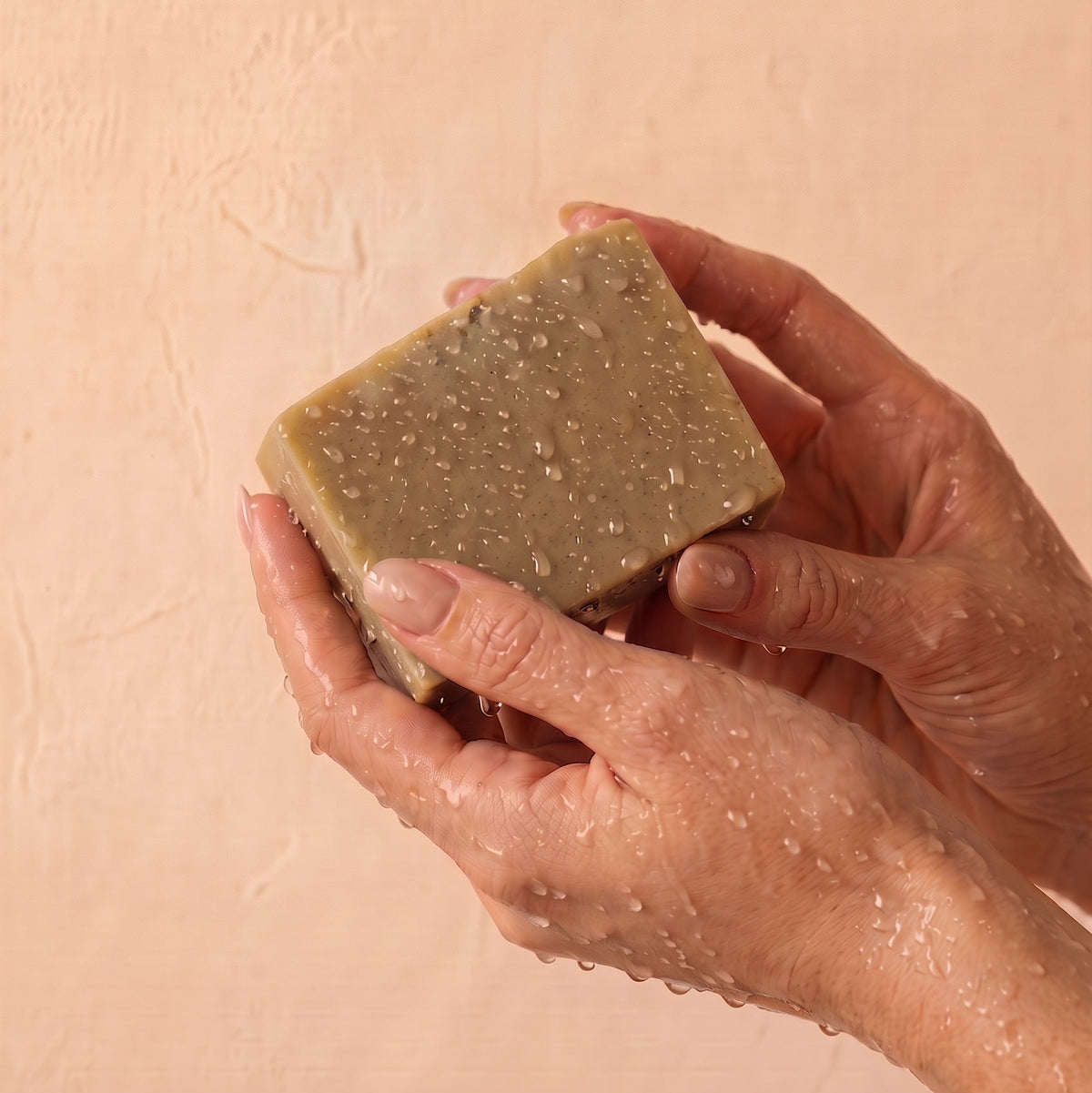 hands holding wet bar of soap