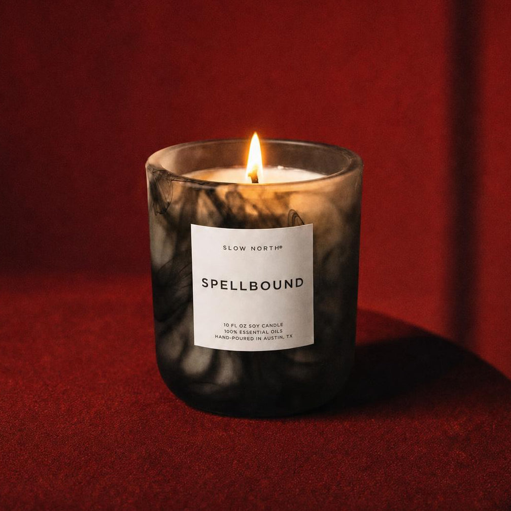 Black and white halloween candle called Spellbound on a red drape background