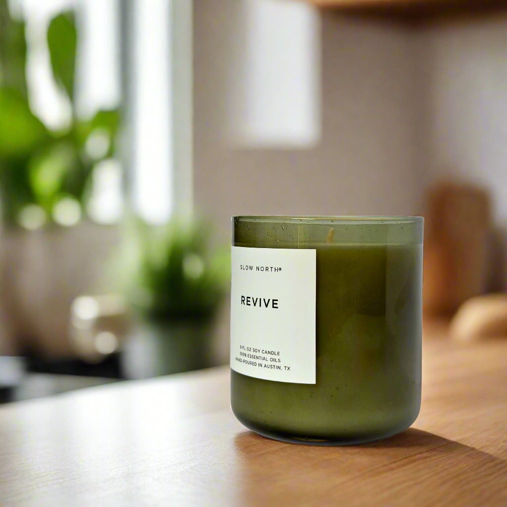 Green candle with a white label in a cozy home