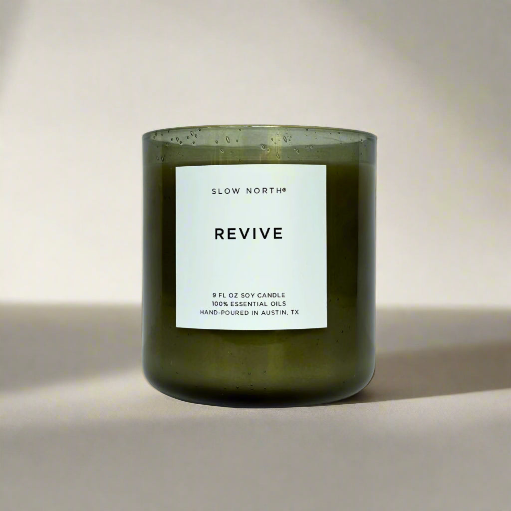 Green candle labeled 'Revive' by Slow North on a tan background