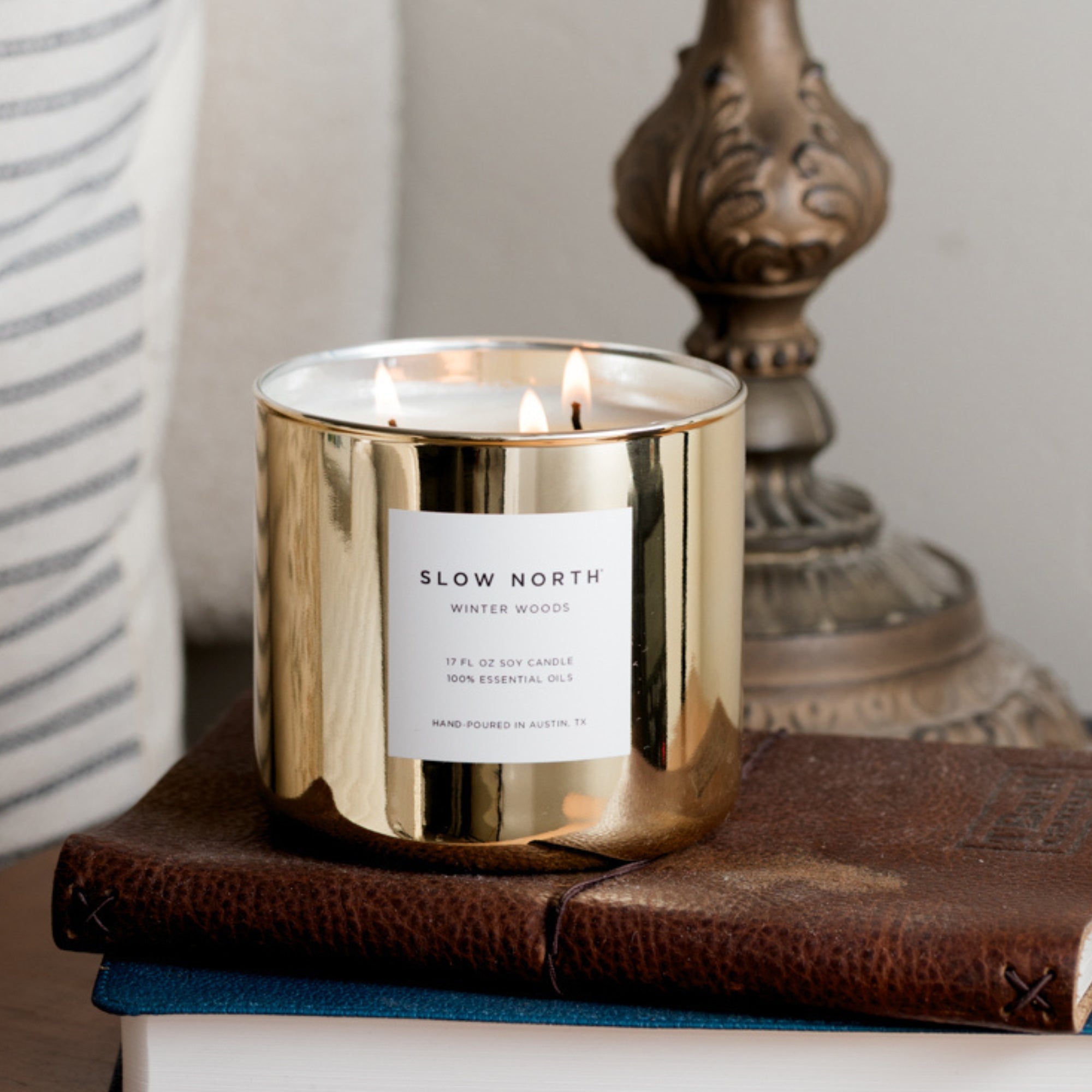 Gold candle with 'Slow North' label on a wooden surface