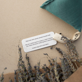 A closeup of the Lagoon Lavender Sachet tag. TEXT: Filled with 100% natural, aromatic lavender buds. Slip into a clothes drawer or hang in a closet to freshen your clothes and linens for insect-repelling benefits. Gently squeeze to reactivate.