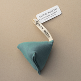 Lavender Sachet - Lagoon, a teal fabric sachet prism on a tan background.