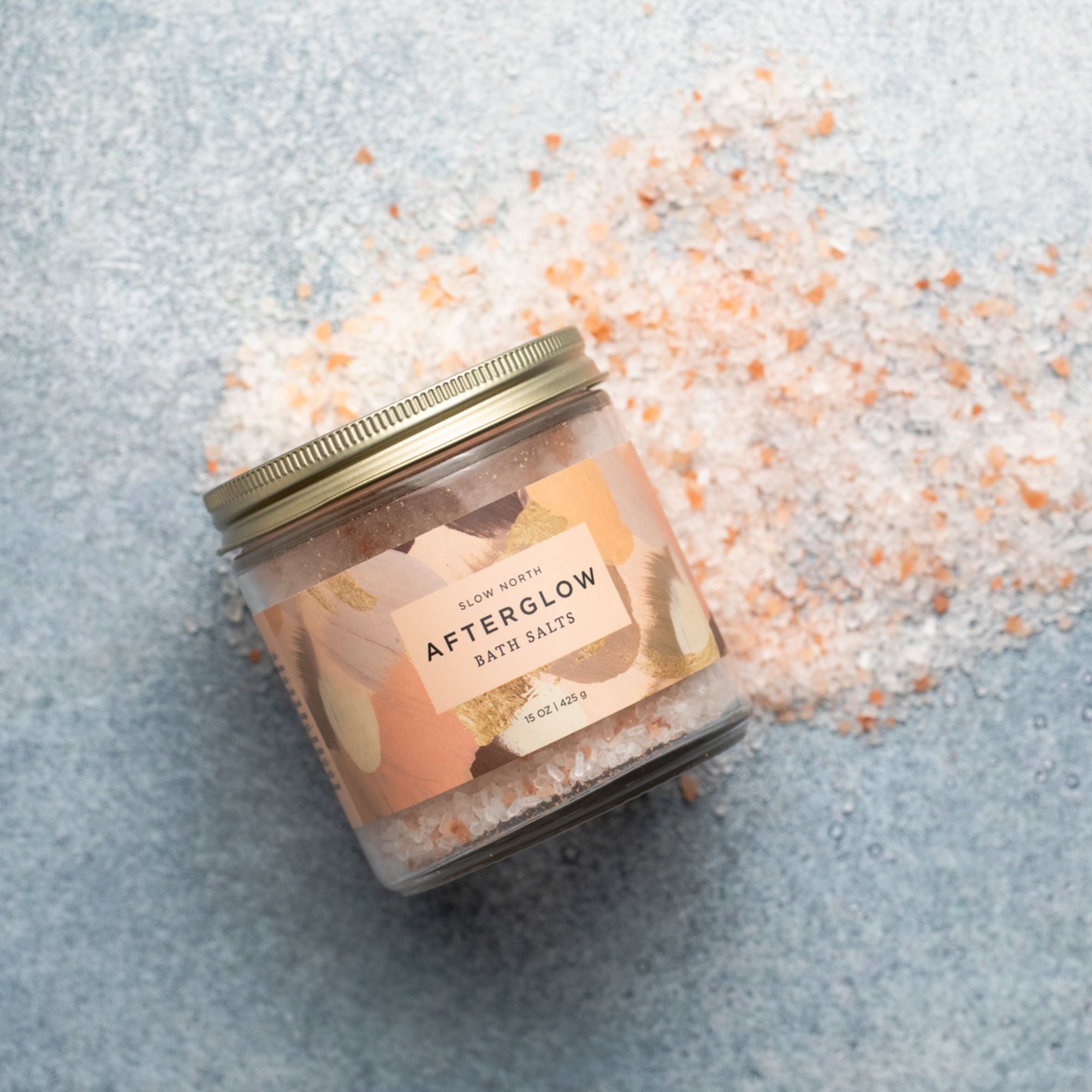 Jar of 'Afterglow' bath salts on a textured surface