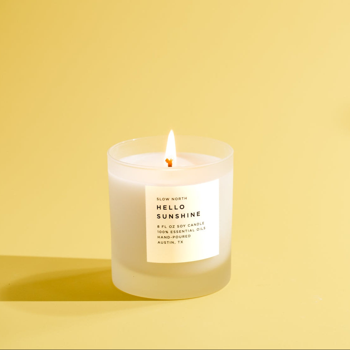 Candle labeled 'Hello Sunshine' on a yellow background