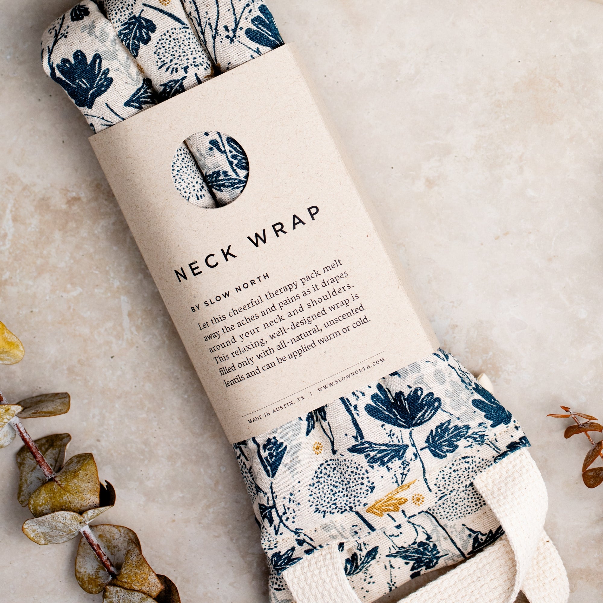 Neck wrap with floral pattern in packaging on a neutral background