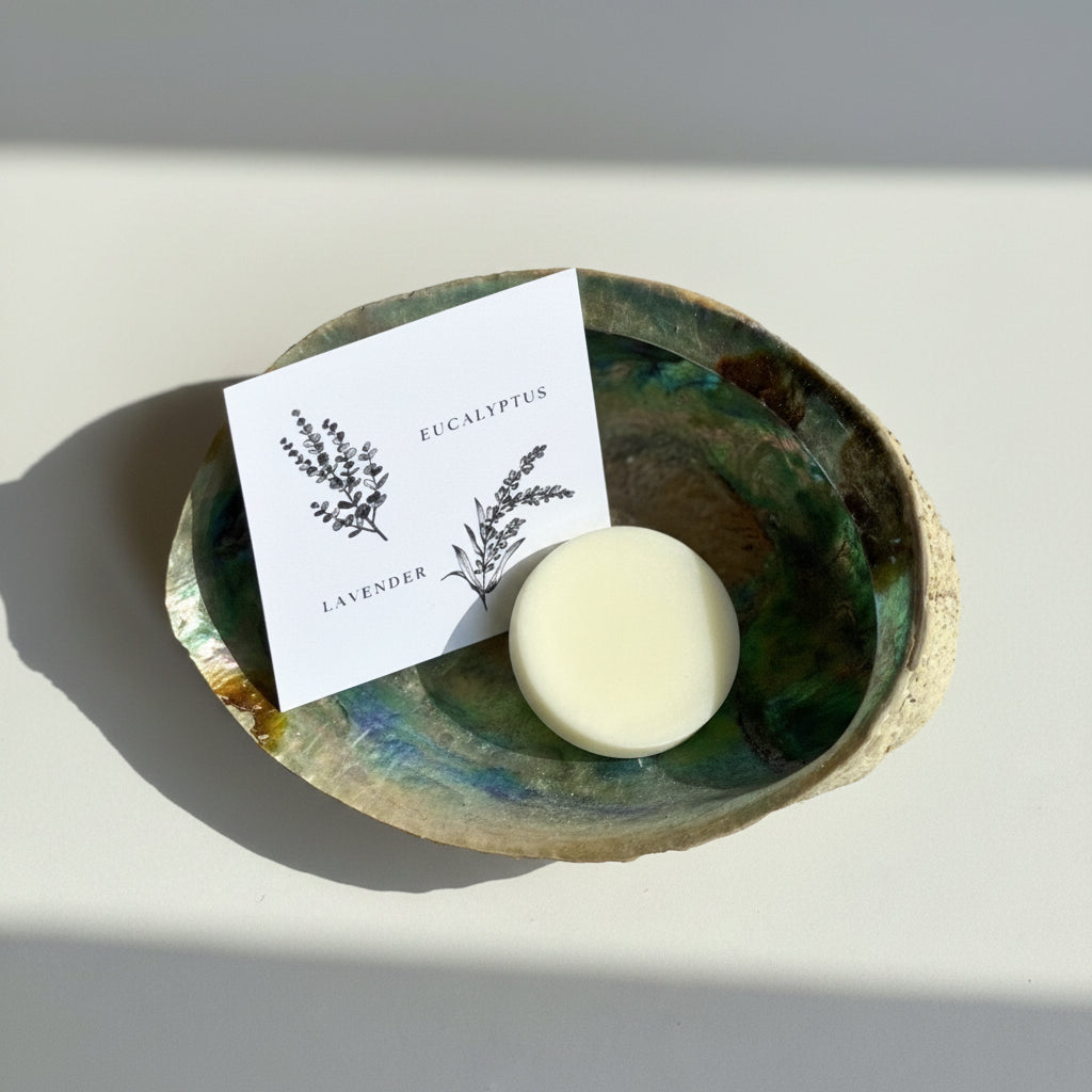 Wax melt scent sample on a decorative abalone shell with a card labeled 'Eucalyptus' and 'Lavender'.