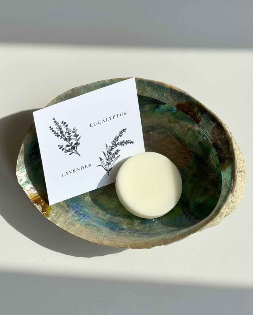 Wax melt scent sample on a decorative abalone shell with a card labeled 'Eucalyptus' and 'Lavender'.