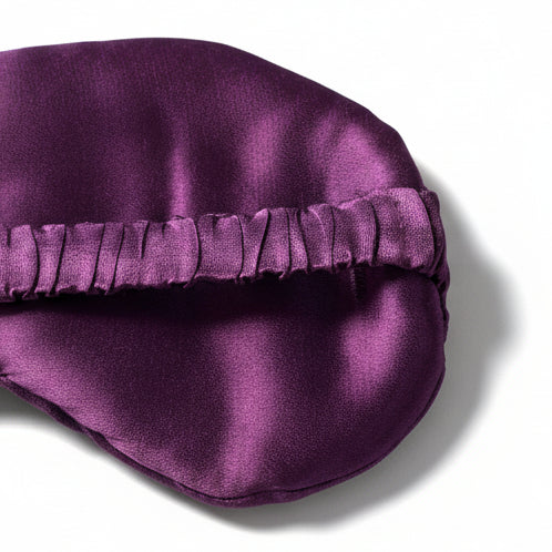 Purple satin eye mask on a white background