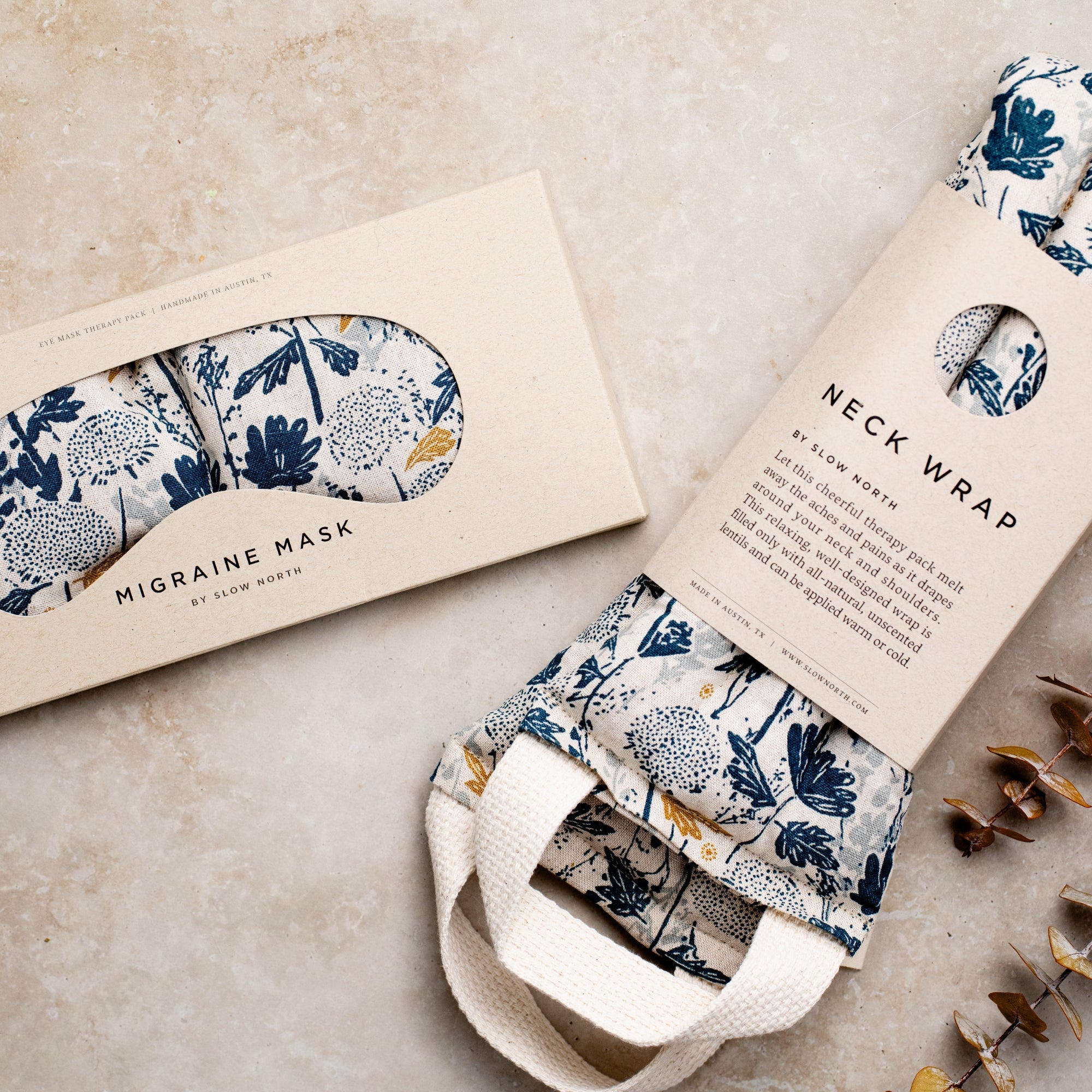 Neck wrap and migraine mask with floral pattern packaging on a neutral background