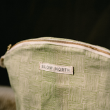 close - up of green handcrafted gold zipper cosmetic bag