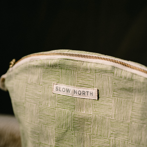 close - up of green handcrafted gold zipper cosmetic bag