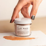 Hand unscrewing Beetroot + Turmeric Clay Mask .75 ounce in clear glass jar with white lld. By Slow North