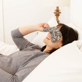 Woman lying in a bed with Eye Mask - Mystical Mushroom pattern on eyes. Made by Slow North