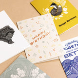 Various Slow North greeting cards on brown background. Happy Birthday Doodles Card by Slow North