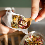 Hand holding spoon with Herbal Bath Tea made by Slow North