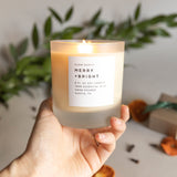 hand holding a lit holiday scented non toxic candle