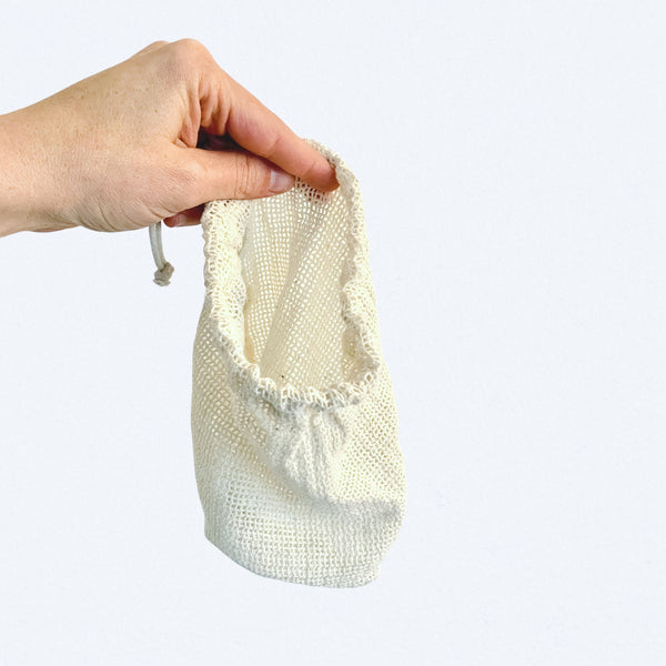 hand holding white mesh bag