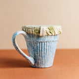 Blue cup covered by green reusable fabric dish cover by Slow North