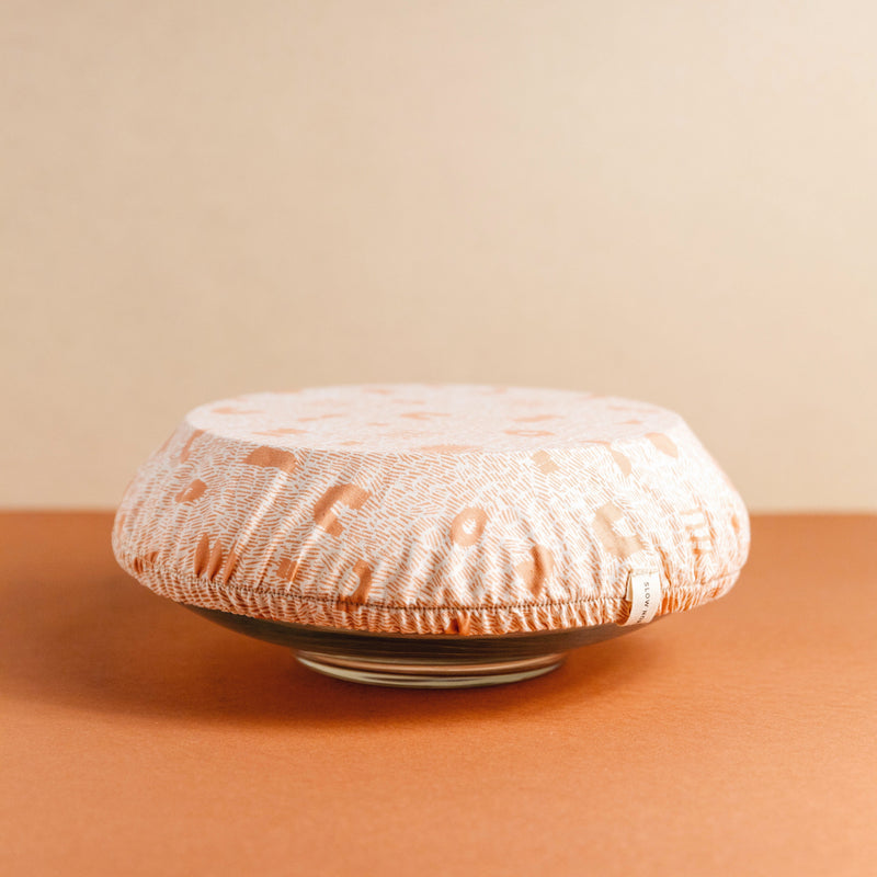 Large bowl covered by pink and white reusable fabric dish cover by Slow North